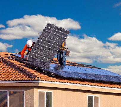 Workers Installing Solar Panels on House Roof.